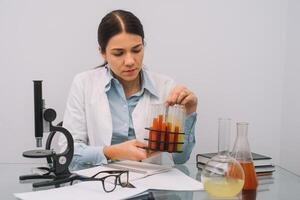 Beautiful medical doctors in gloves and glasses are working with substances in test tubes and microscope at the lab. Photo of attractive concentrated female doctor writing prescription on special form