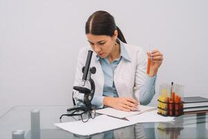 un hermosa hembra médico o científico investigador utilizando su microscopio en un laboratorio. foto