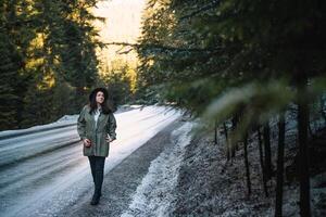 Happy girl with hat in forest at mountain road background, Relax time on holiday concept travel ,color of vintage tone and soft focus. photo