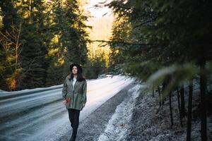 Happy girl with hat in forest at mountain road background, Relax time on holiday concept travel ,color of vintage tone and soft focus. photo