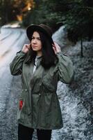 Happy girl with hat in forest at mountain road background, Relax time on holiday concept travel ,color of vintage tone and soft focus. photo