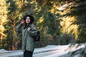 Happy girl with hat in forest at mountain road background, Relax time on holiday concept travel ,color of vintage tone and soft focus. photo