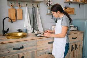 Young happy mom and her baby cook cookies at home in the kitchen. Christmas Homemade Gingerbread. cute boy with mother in white uniform and hat cooked chocolate cookies photo