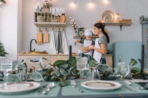 Young happy mom and her baby cook cookies at home in the kitchen. Christmas Homemade Gingerbread. cute boy with mother in white uniform and hat cooked chocolate cookies photo