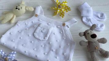 Set of white clothes and accessories for newborn baby. video