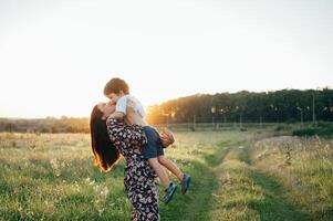 Stilish mother and handsome son having fun on the nature. Happy family concept. Beauty nature scene with family outdoor lifestyle. Happy family resting together. Happiness in family life. Mothers day photo