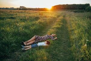 Stilish mother and handsome son having fun on the nature. Happy family concept. Beauty nature scene with family outdoor lifestyle. Happy family resting together. Happiness in family life. Mothers day photo