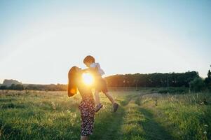 elegante madre y hermoso hijo teniendo divertido en el naturaleza. contento familia concepto. belleza naturaleza escena con familia al aire libre estilo de vida. contento familia descansando juntos. felicidad en familia vida. madres día. foto