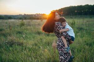 Stilish mother and handsome son having fun on the nature. Happy family concept. Beauty nature scene with family outdoor lifestyle. Happy family resting together. Happiness in family life. Mothers day photo