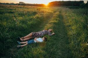 elegante madre y hermoso hijo teniendo divertido en el naturaleza. contento familia concepto. belleza naturaleza escena con familia al aire libre estilo de vida. contento familia descansando juntos. felicidad en familia vida. madres día foto