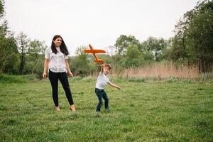 Stilish mother and handsome son having fun on the nature. Happy family concept. Beauty nature scene with family outdoor lifestyle. Happy family resting together. Happiness in family life. Mothers day photo