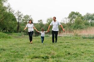 Happy family mother father and child son on nature on sunset. Mom, Dad and kid laughing and hugging, enjoying nature outside. Sunny day, good mood. concept of a happy family. photo