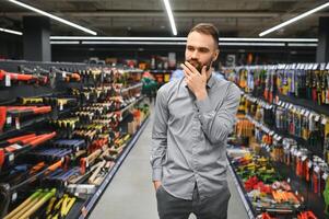 retrato de contento maduro hombre en pie en hardware Tienda foto