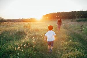 Stilish mother and handsome son having fun on the nature. Happy family concept. Beauty nature scene with family outdoor lifestyle. Happy family resting together. Happiness in family life. Mothers day photo