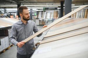 man choosing laminate samples in hardware store photo