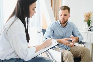 Portrait of female psychiatrist interviewing handicapped man during therapy session, copy space. photo