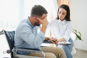 Portrait of female psychiatrist interviewing handicapped man during therapy session, copy space. photo