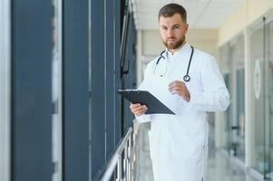 Portrait of a male doctor standing in a hospital corridor. photo