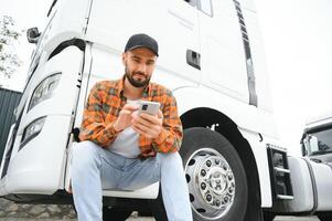 hombre camionero hablando en el teléfono por su blanco camión foto