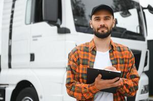 camión conductor comprobación envío lista mientras en pie en estacionamiento lote de distribución almacén foto