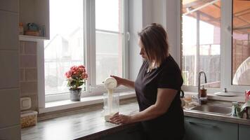 vrouw opruimen omhoog de keuken en gieten meel in een houder organiserende ruimte video