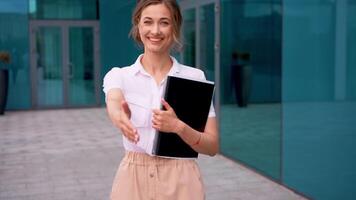 Smiling businesswoman offering handshake outside office building video