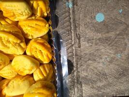 Close up of nastar cookies or pineapple tart lined up neatly on black cupcake paper. photo