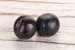 Two ripe sweet black plums photo