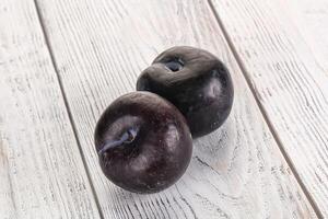 Two ripe sweet black plums photo