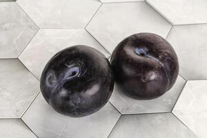 Two ripe sweet black plums photo