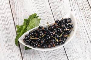 Juicy black currant berries in the bowl photo