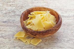 Sliced parmesan cheese heap in the bowl photo