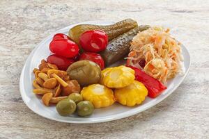 Plate with pickled vegetables and mushrooms photo