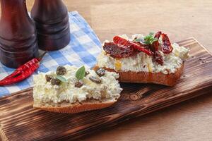 bruschetta with soft cheese capers and tomato photo