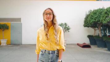 une femme avec des lunettes sourit à le caméra video