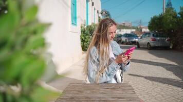 gelukkig vrouw toerist gebruik makend van smartphone in straat cafe video