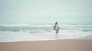 reizen concept gelukkig vrouw rennen oceaan strand en bochten in de omgeving van vol lengte video