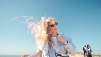 Closeup of young woman face covered with flying hair in windy day handheld video