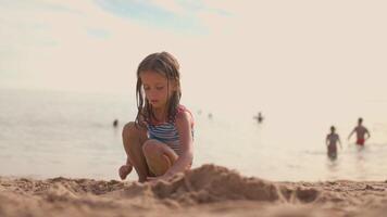 Little girl play on sea beach on summer vacation with people on background video