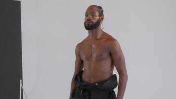 Photographer take a picture shirtless African-American gay man with makeup in studio video