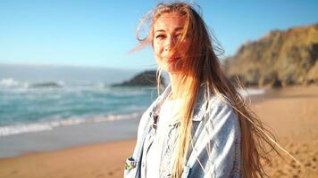 Woman with happy smile and long hair dressed denim shirt on beach at sunset video