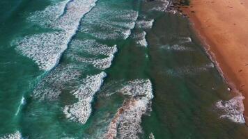 Aerial shot of foamy sea waves rolling towards shore at beach video