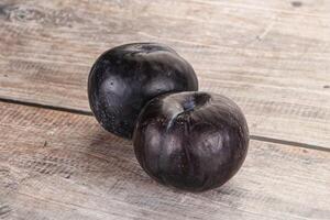 Two ripe sweet black plums photo