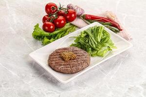 Frilled beef burger cutlet with iceberg photo