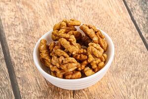 Cracked unshelled walnut in the bowl photo