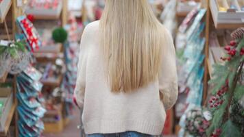 un mujer con largo rubia pelo caminando mediante un Tienda video