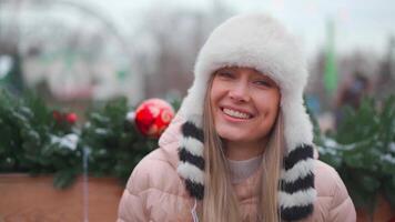 un mujer en un sombrero es sonriente mientras participación regalos video