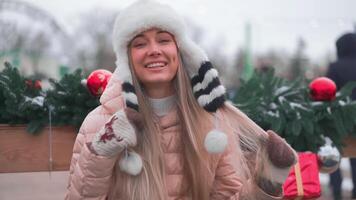 une femme dans une chapeau est souriant tandis que en portant présente video