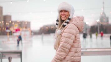 une femme dans une rose manteau et chapeau sur un la glace patinoire video