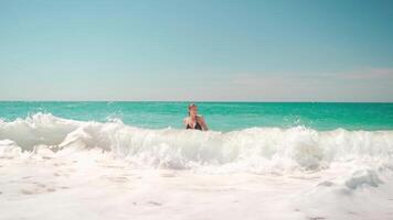 un' donna nel un' bikini in piedi nel il oceano video